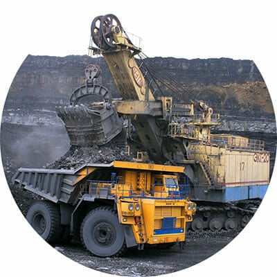 Excavator dumping its contents into a loader at a mining operation