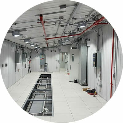 Packaged Turnkey Solutions & System Integration, Modular Building (e-house) with lighting fixtures installed on the ceiling and cable trays installed underneath the floor